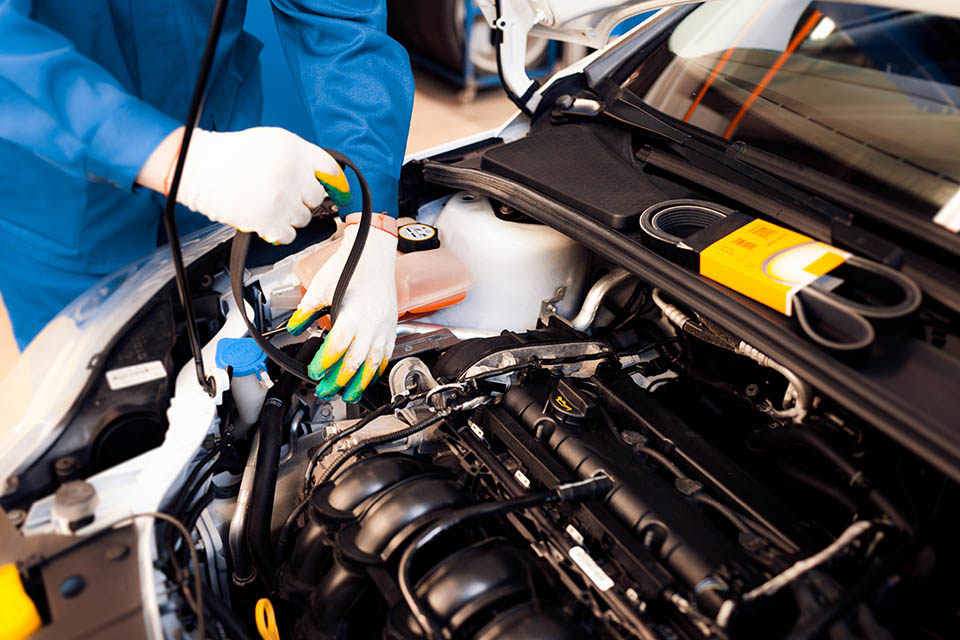 Car mechanic replacing timing belt at camshaft of modern engine